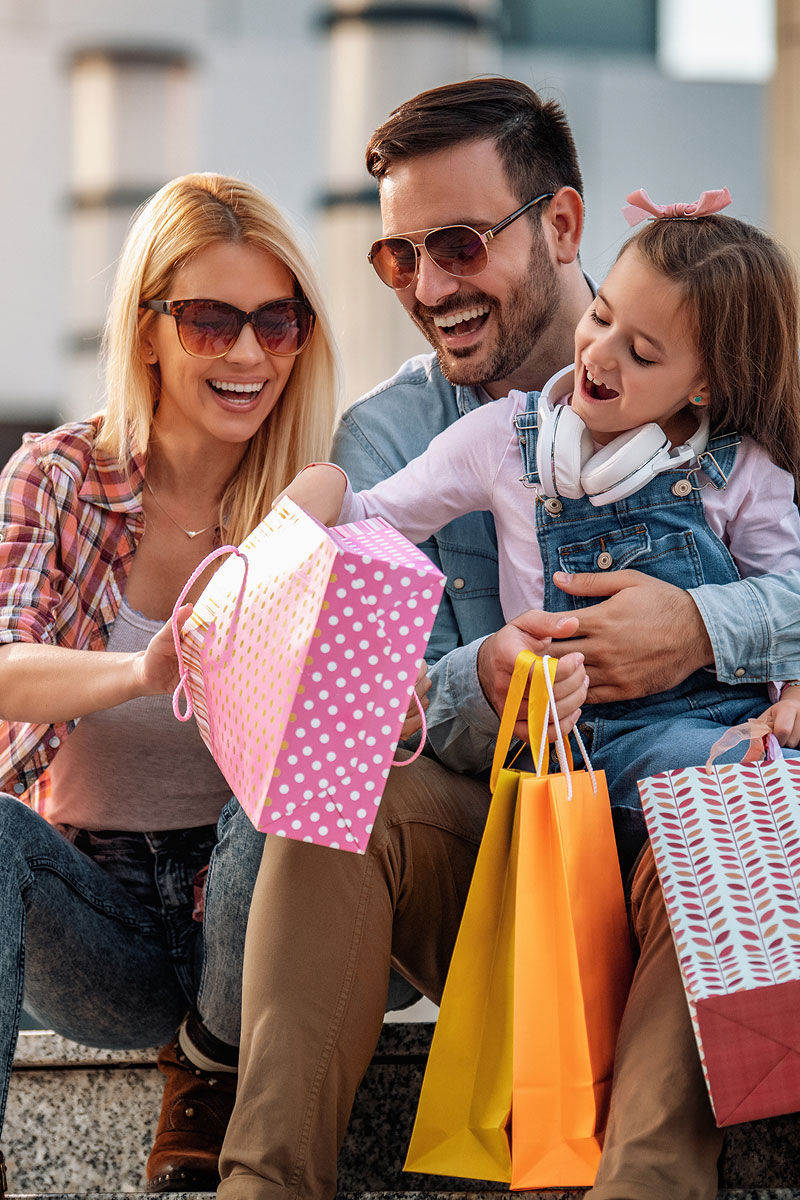 Complete Beauty - family smiling with bags in hand