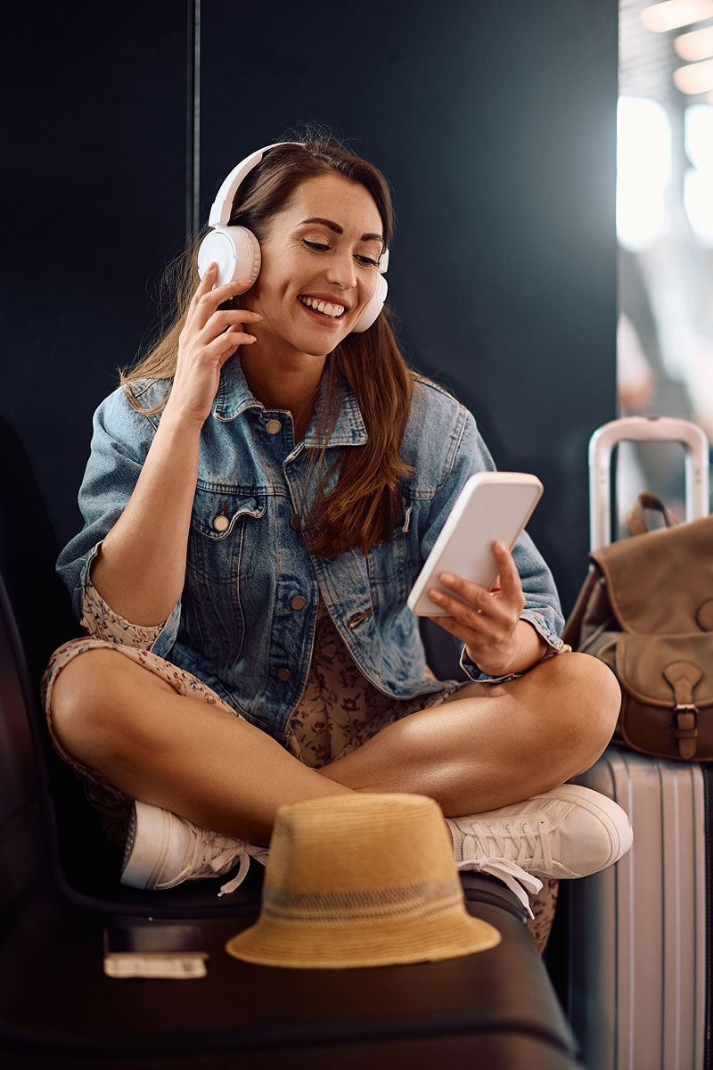 Consumer Decision Tree - woman smiling looking at phone with headphones on