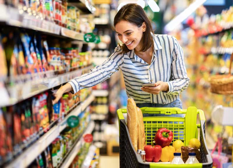 NCS Targeting - a smiling woman selecting items from a shelf in a grocery store