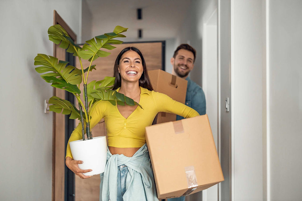 Complete Market - a smiling couple moving into house with woman holding a pot plant